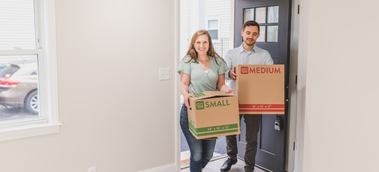 A couple carrying boxes