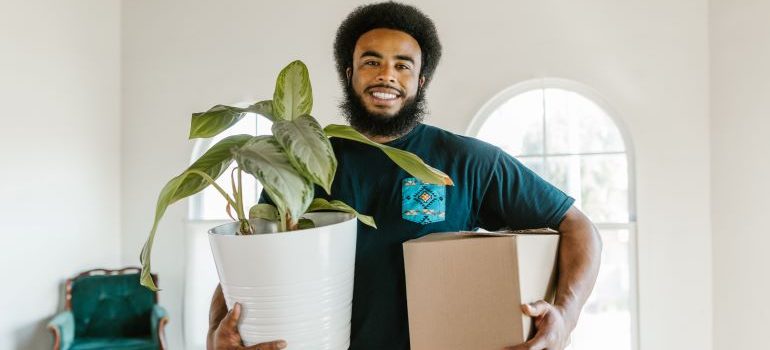 mover holding a box and a plant