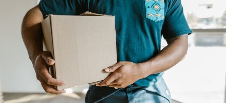 Professional mover holding a card box 