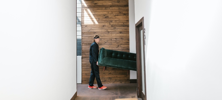 movers carrying a green sofa