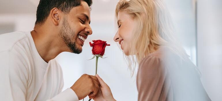 A man givign a woman a rose