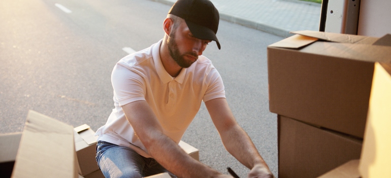 a mover doing inventory in the back of the moving van