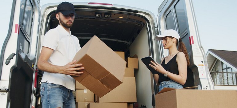 man and woman packing boxes into a van