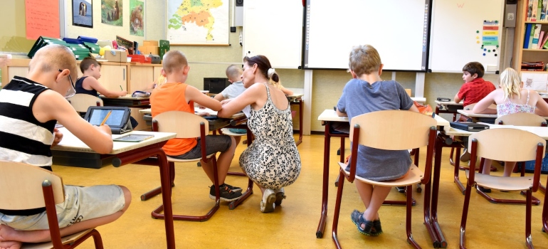 children living in key west sitting on brown chairs inside a classroom