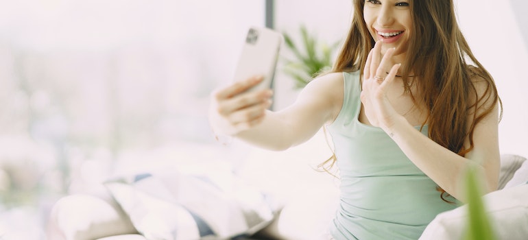 Cheerful young woman video calling on one of the best apps to make friends