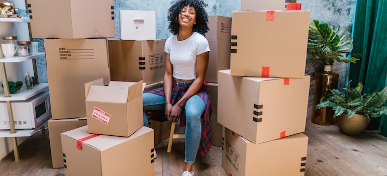 A woman sitting in front of cardboard boxes