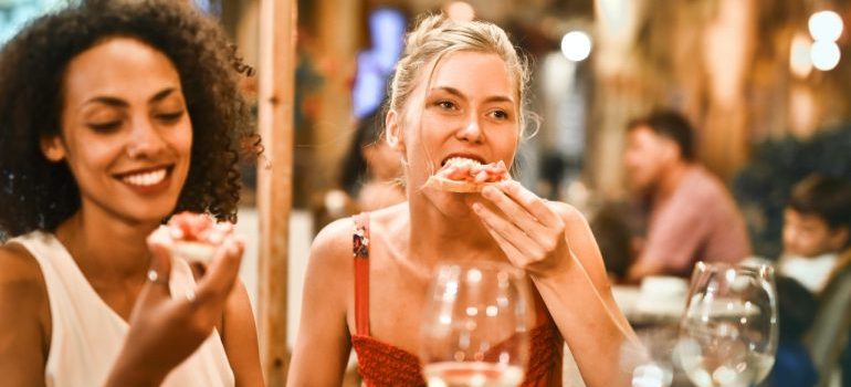 two women eating a pizza in Orlando, one of the best foodie cities in Florida