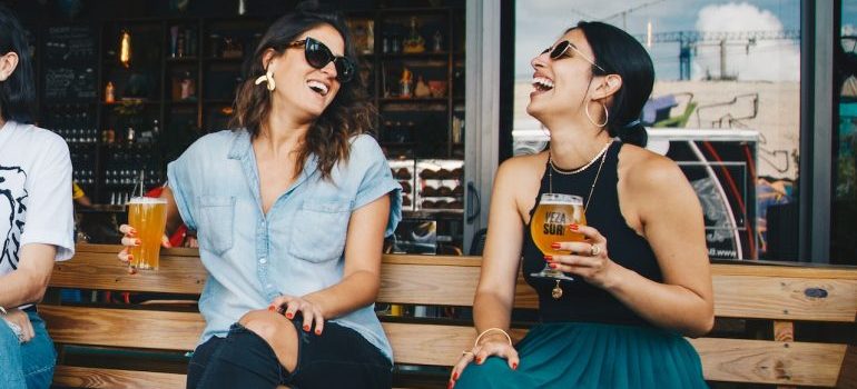 girlfriends drinking beer and laughing in one of the best foodie cities in Florida