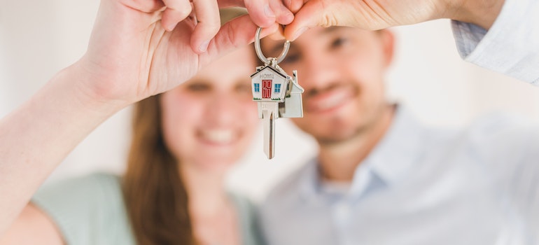 Couple holding a key after moving from Fort Lauderdale to Miami