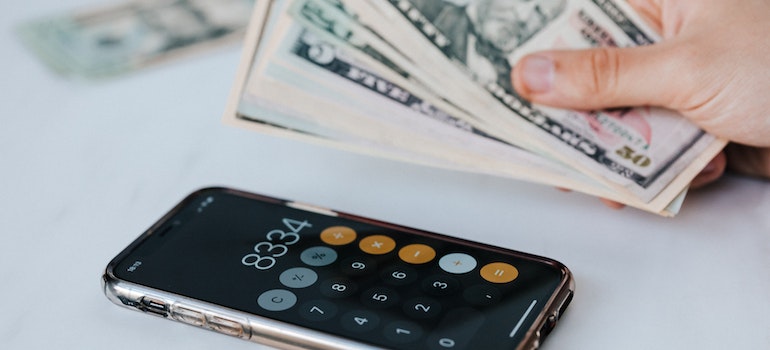 A person using a calculator to figure out the cost and decide whether to rent or buy a home in Pompano Beach