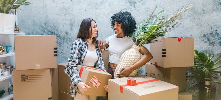 Two women smiling while packing