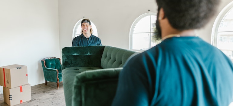 pair of movers in uniform moving a couch