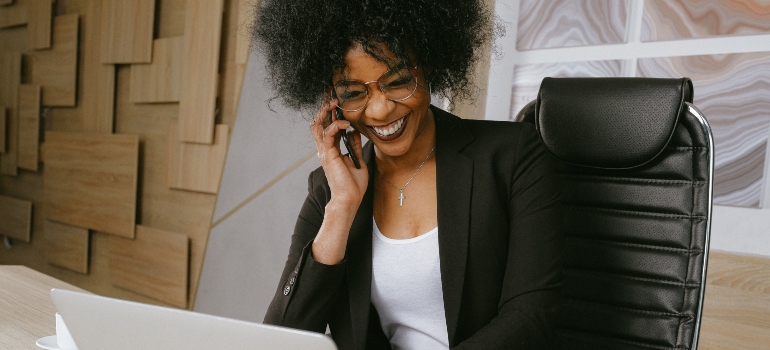 A woman smiling while talking on the phone