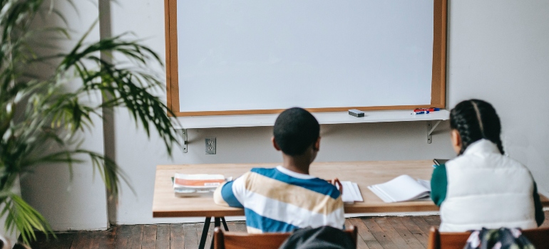 A boy and a girl sitting in a classroom after moving from Tallahassee to Orlando