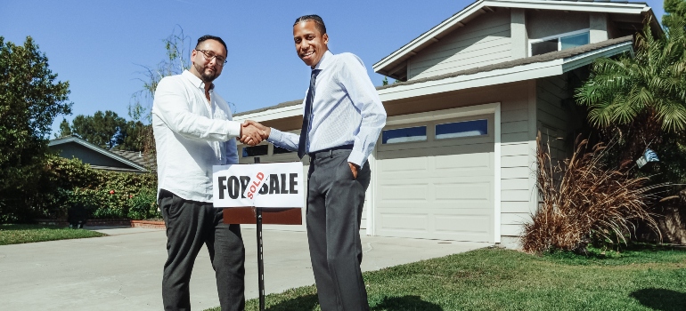 Two men shaking hands in front of a 