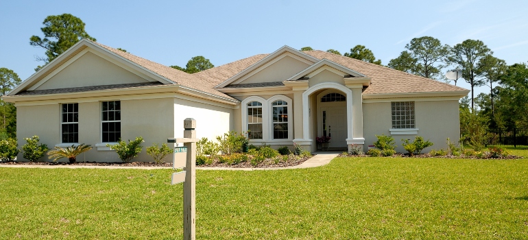 A white one-story home on a grass field