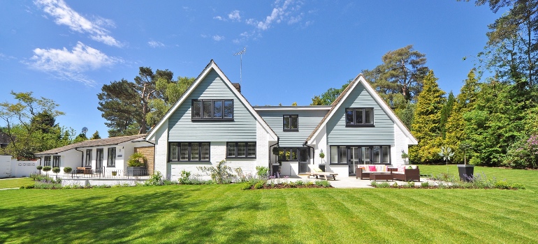 White and grey wooden home on a grass field