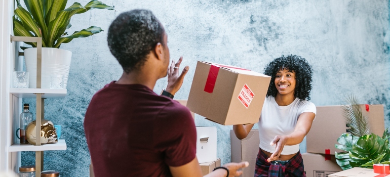 A man and a woman playing with a moving box