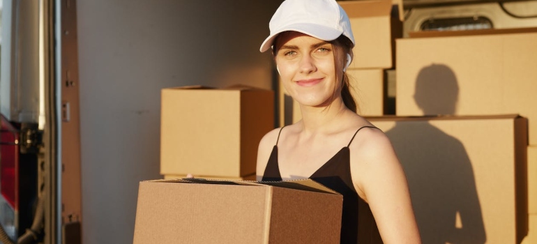 A woman carrying a moving box