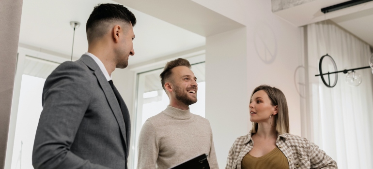A couple talking to a realtor in an open house