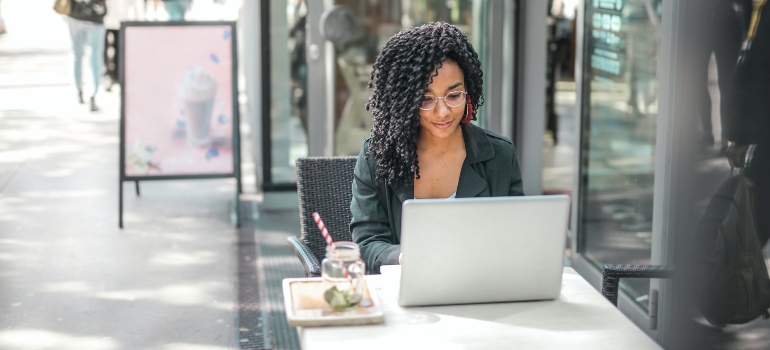 A woman using her laptop in a street cafe