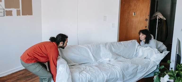 A couple carrying a sofa