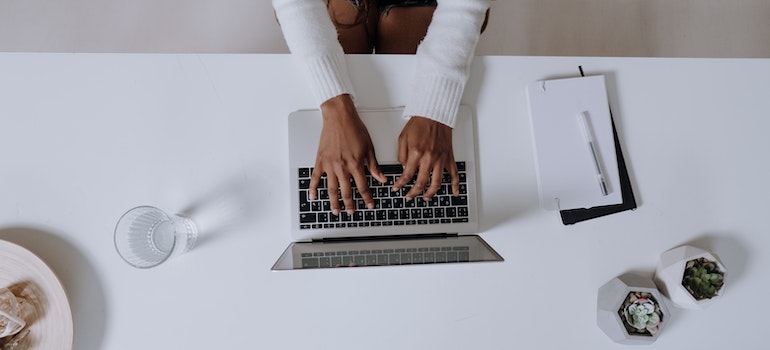 Person typing something on their computer while writing about the Florida housing market.