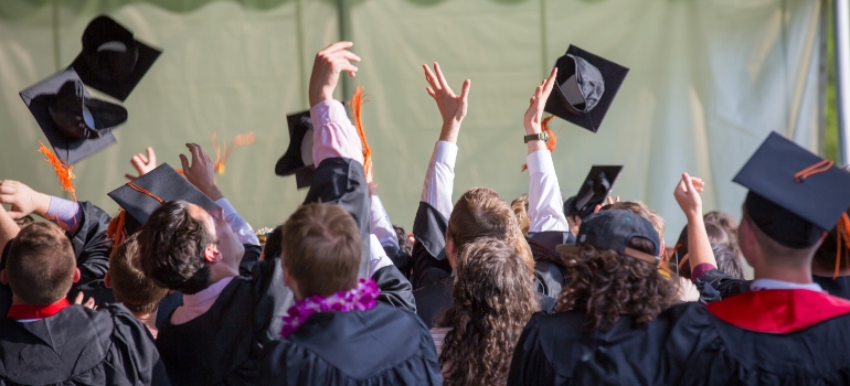 People graduating  and throwing their hats in the air