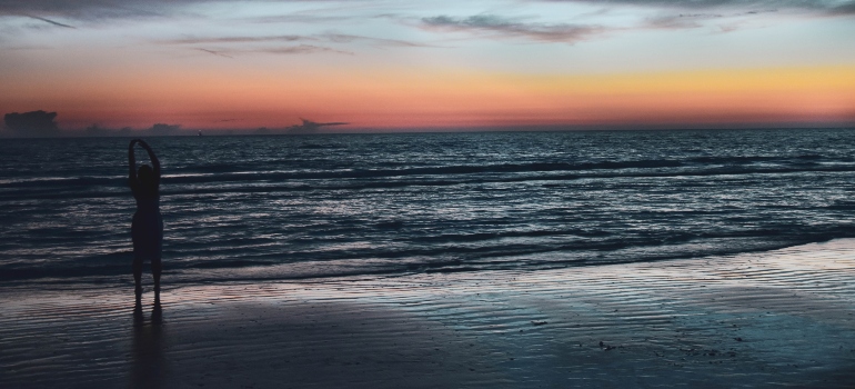 A silhouette of a woman on a beach during sunset