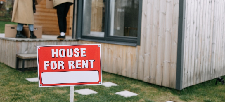 A house for rent sign with people who are moving from Miramar to Hialeah on the porch