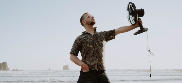 a man holding a cooling fan