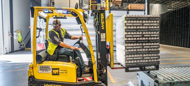 a man driving a yellow forklift