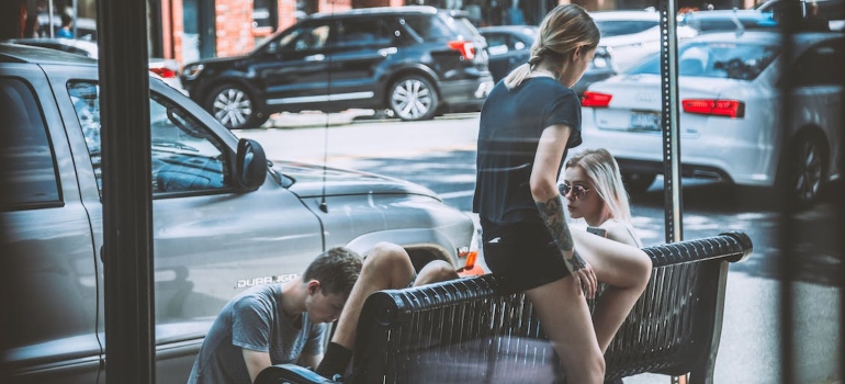 teenagers hanging out at a bench