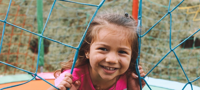 A happy kid on a trampoline in a backyard