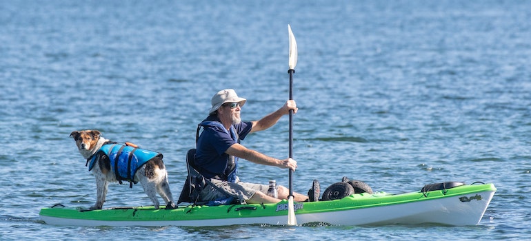 a man with his dog on a kayak