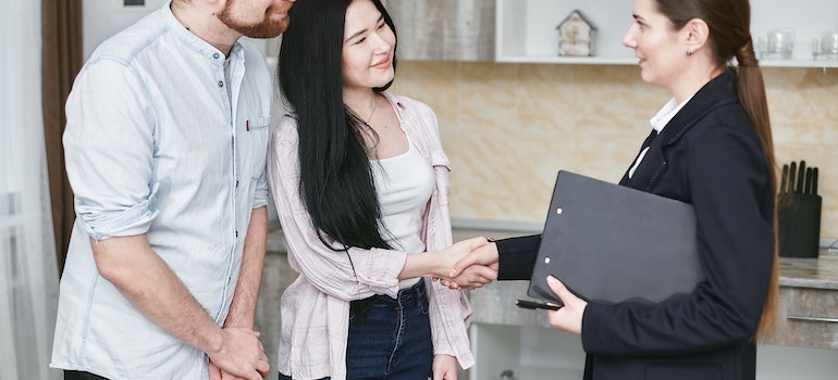 a couple shaking hands with an insurance agent