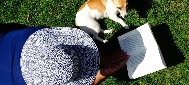 a woman reading about the best dog friendly cities in Florida with her dog beside her