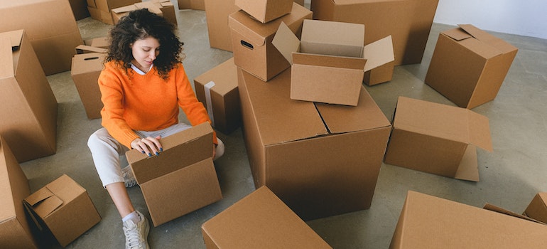 A woman sitting among moving boxes