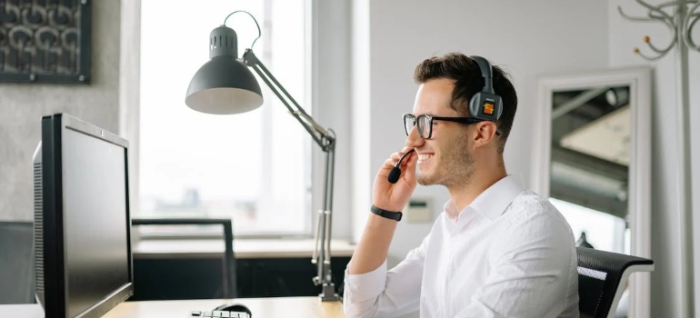 a rental agent with a headset on a phone with a client