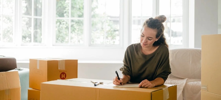a woman writing a moving plan and strategic timing tips for moving day