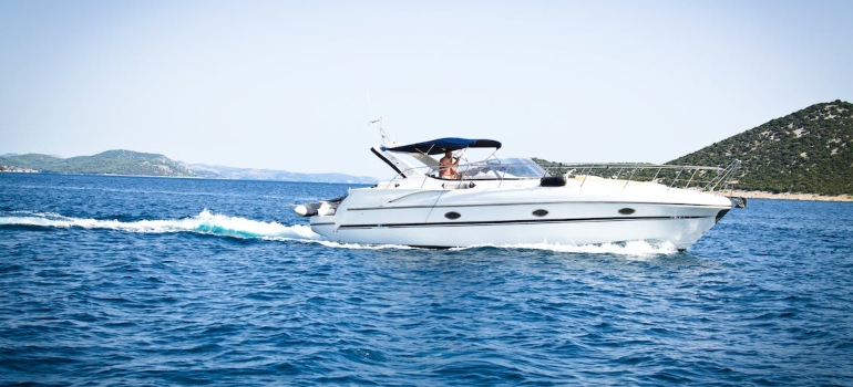 a small white yacht in crystal blue waters near the coast