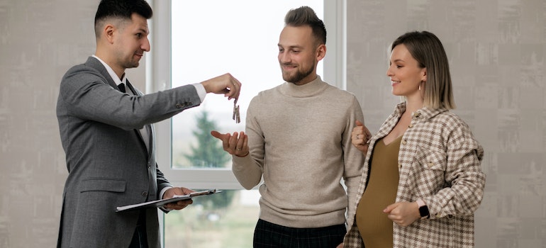 Realtor handing over keys to a couple