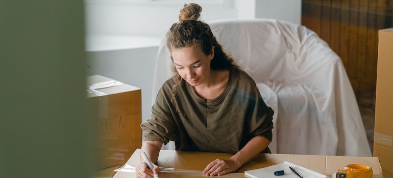 a woman writing down all the overlooked moving tasks