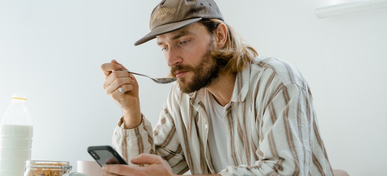 A man eating breakfast and researching how to stay motivated on moving day.