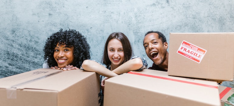 People sitting behind boxes and smiling