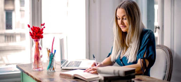 Woman at her desk researching ways for creating a productive workspace after moving