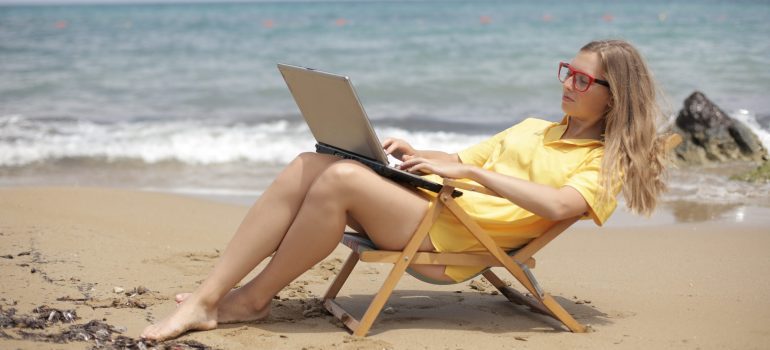 Woman using her laptop at the beach