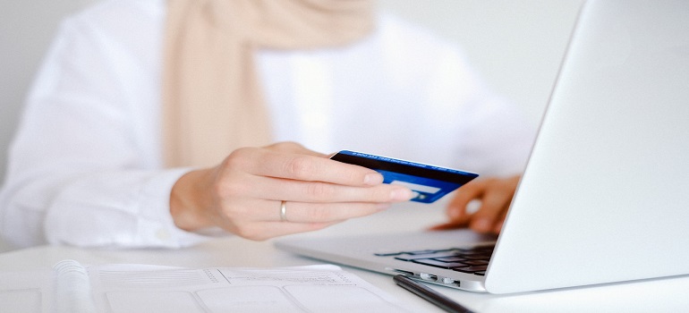 person in white holding a credit card