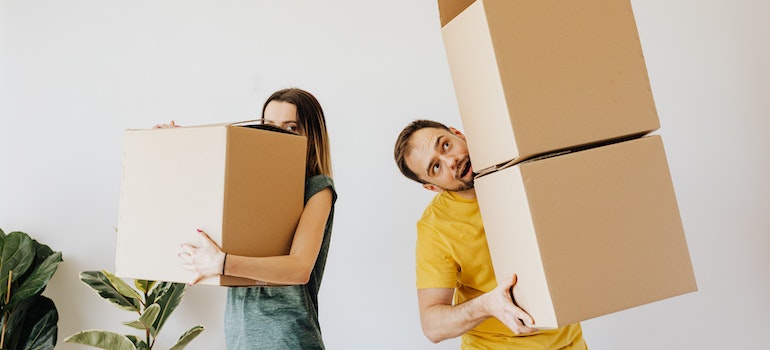 two people carrying boxes while moving from Miami to Cocoa Beach