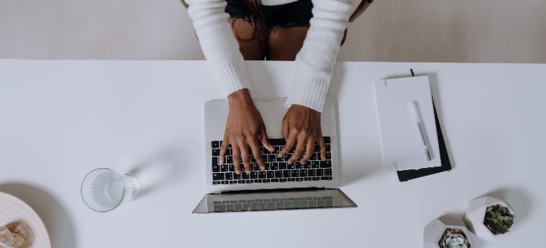 A woman on her laptop managing digital files before the move.